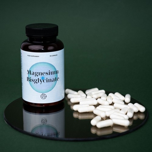 Magnesium Bisglicinate-1.jpgMagnesium Bisglycinate.jpg. Pojemnik z ciemnego szkła- butelka. Niebieska ulotka , naśrodku ciemno-niebieskie kółko z napisem Magnesium Bisglycinate. Butelka stoi na stoliku obok rozsypane kapsułki. Oferta Jemy Zdrowo