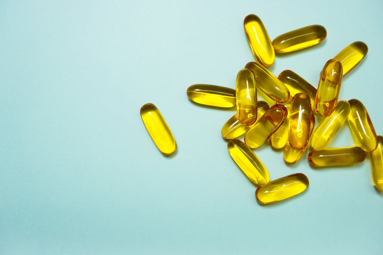 Kwasy Omega-3 , kapsułki z żółtym olejem w środku.